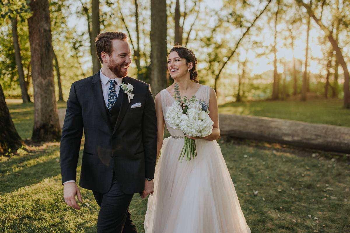 Married couple walking through the forest during sunset during a late summer day.