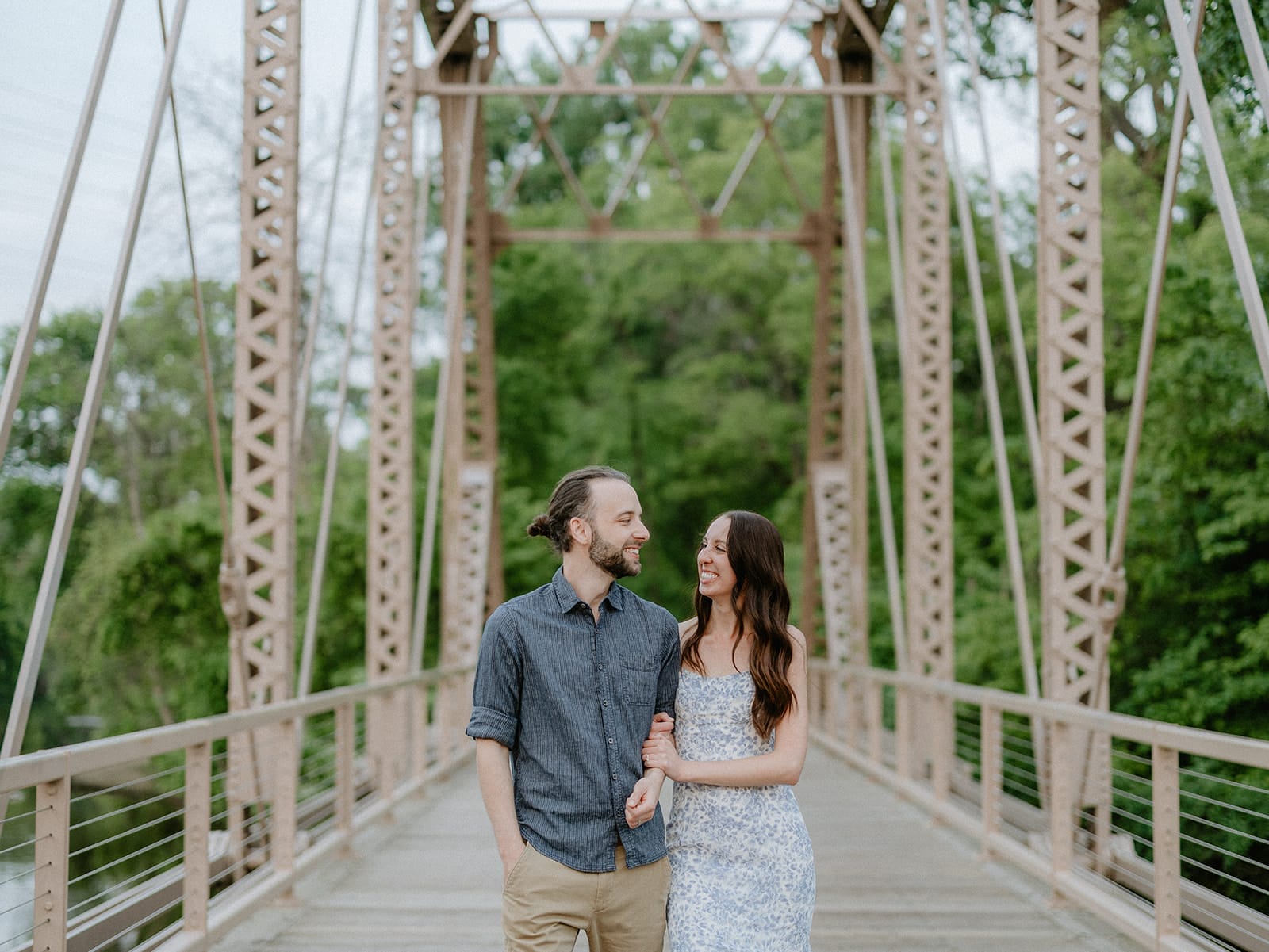 Couple laughing together by the river on Nicollet Island during their Minneapolis engagement photos